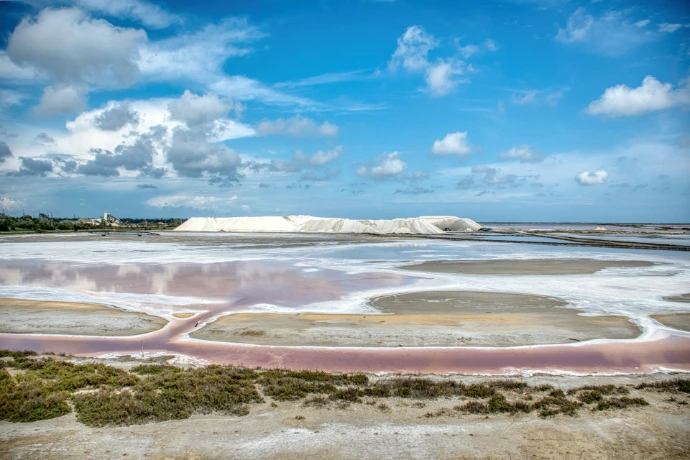 Pink salt flats with white mountains under blue sky